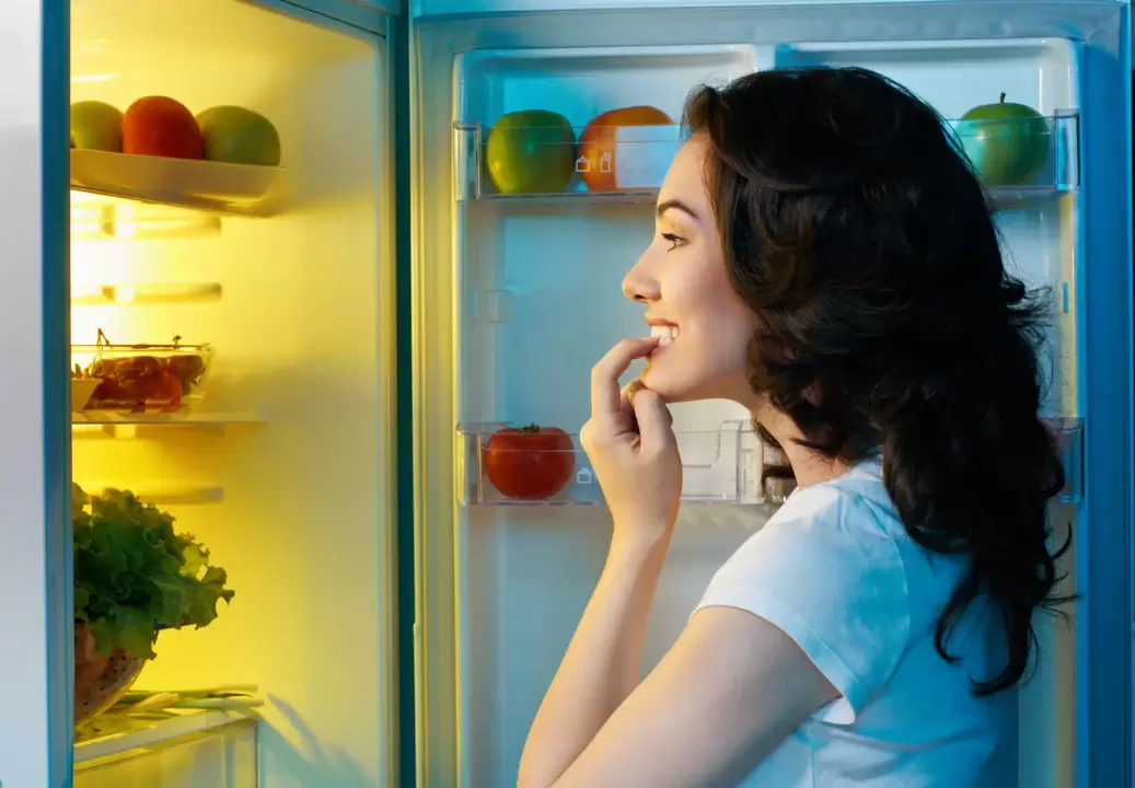 djevojka gleda u hladnjak tijekom brzog mršavljenja